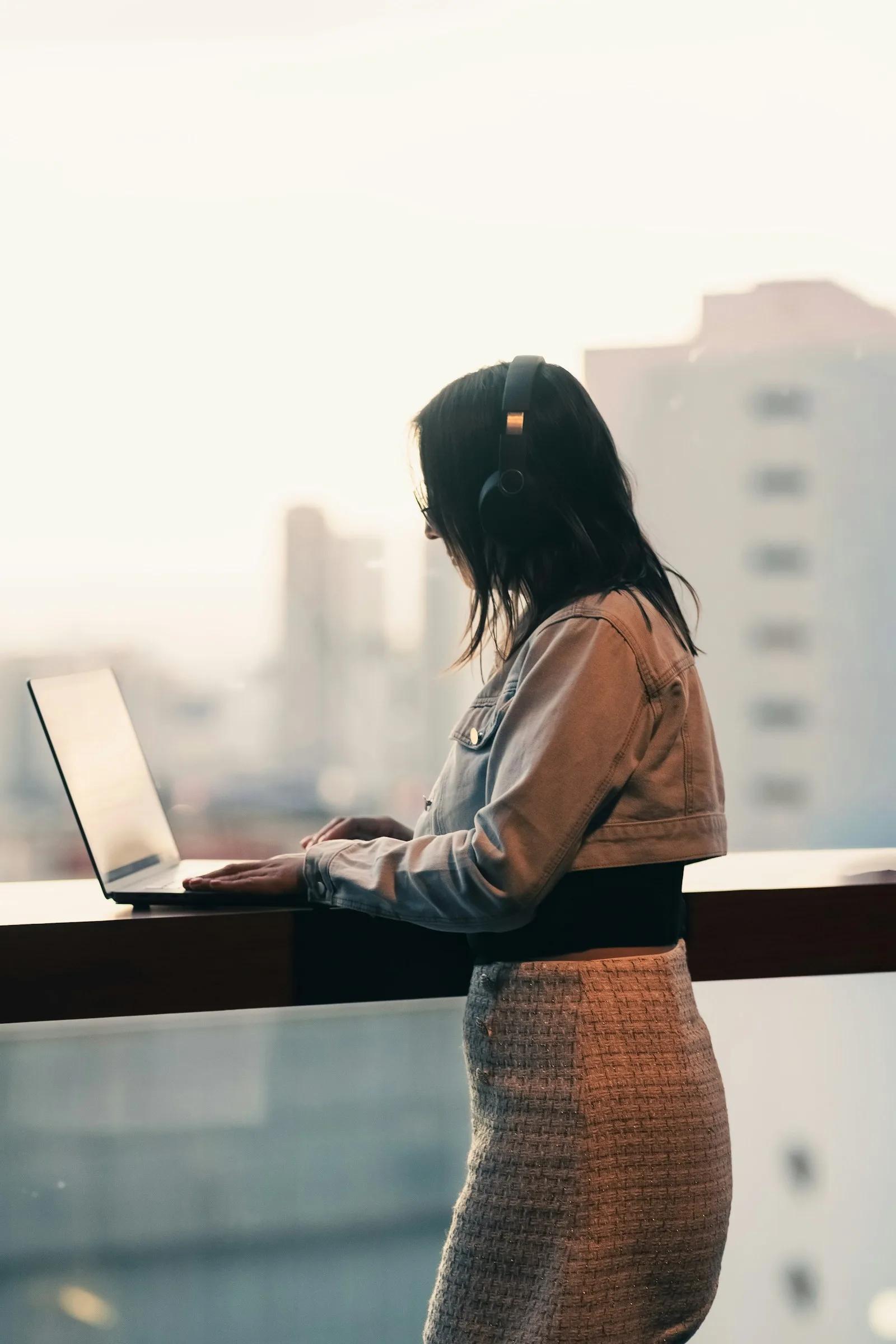 A professional working on a laptop while wearing headphones