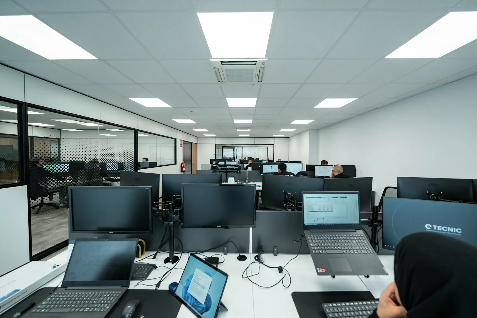 A technical team working at computers in a modern office