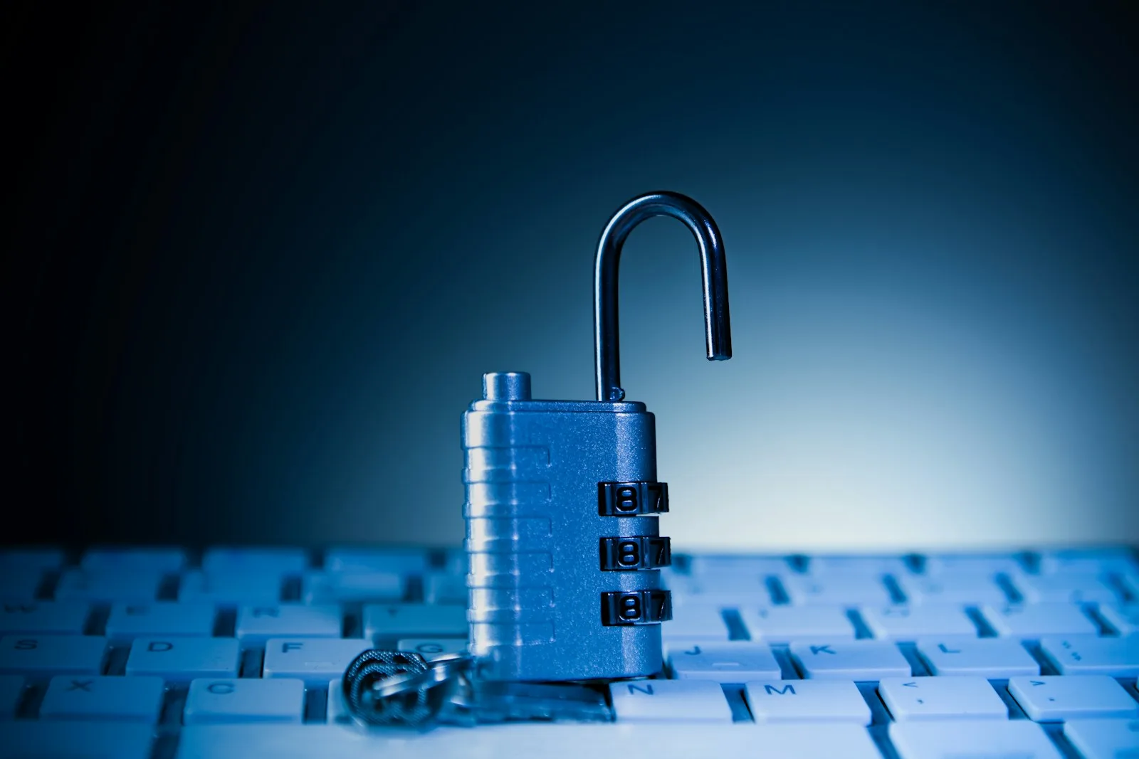 An open padlock resting on a computer keyboard